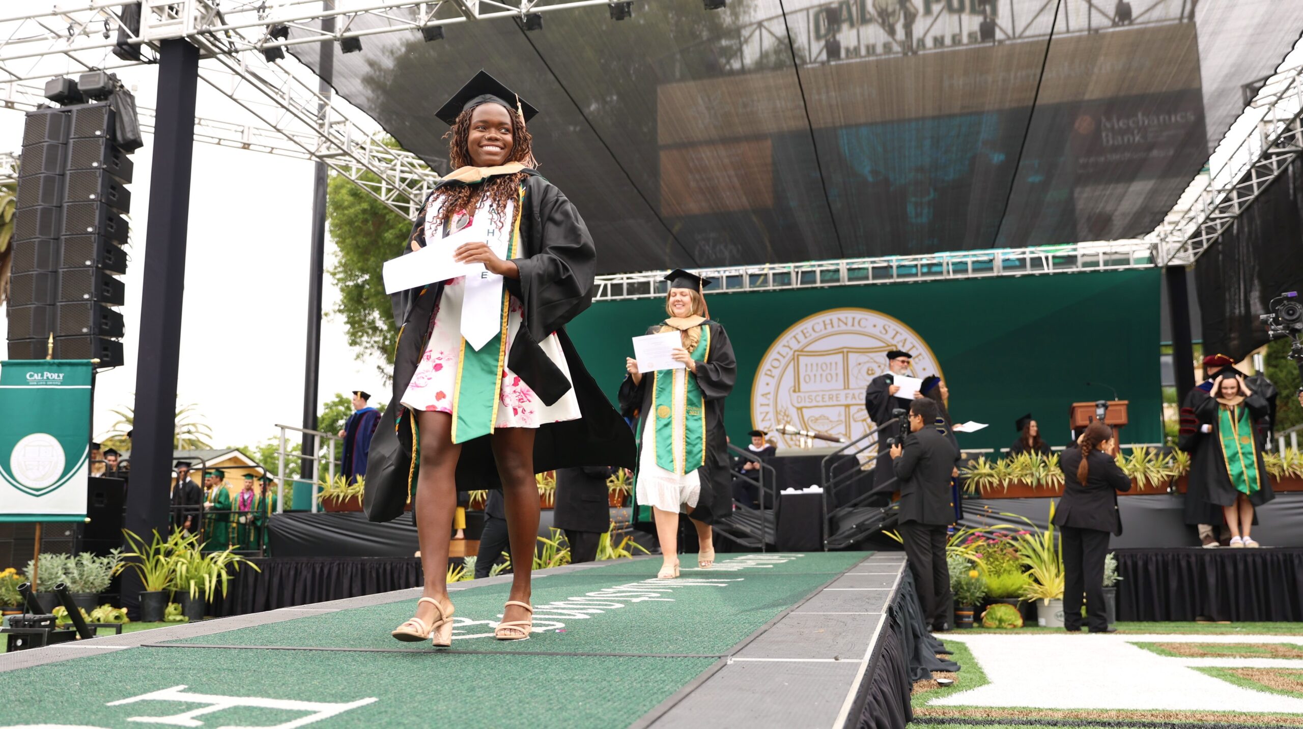 Happy graduating student walking with diploma